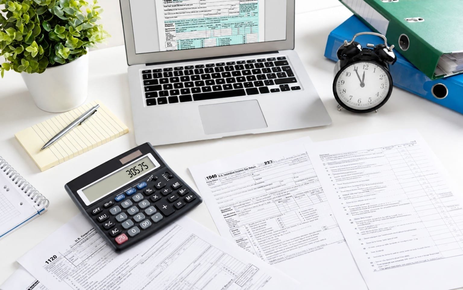 Organized tax and bookkeeping workspace with laptop and financial documents